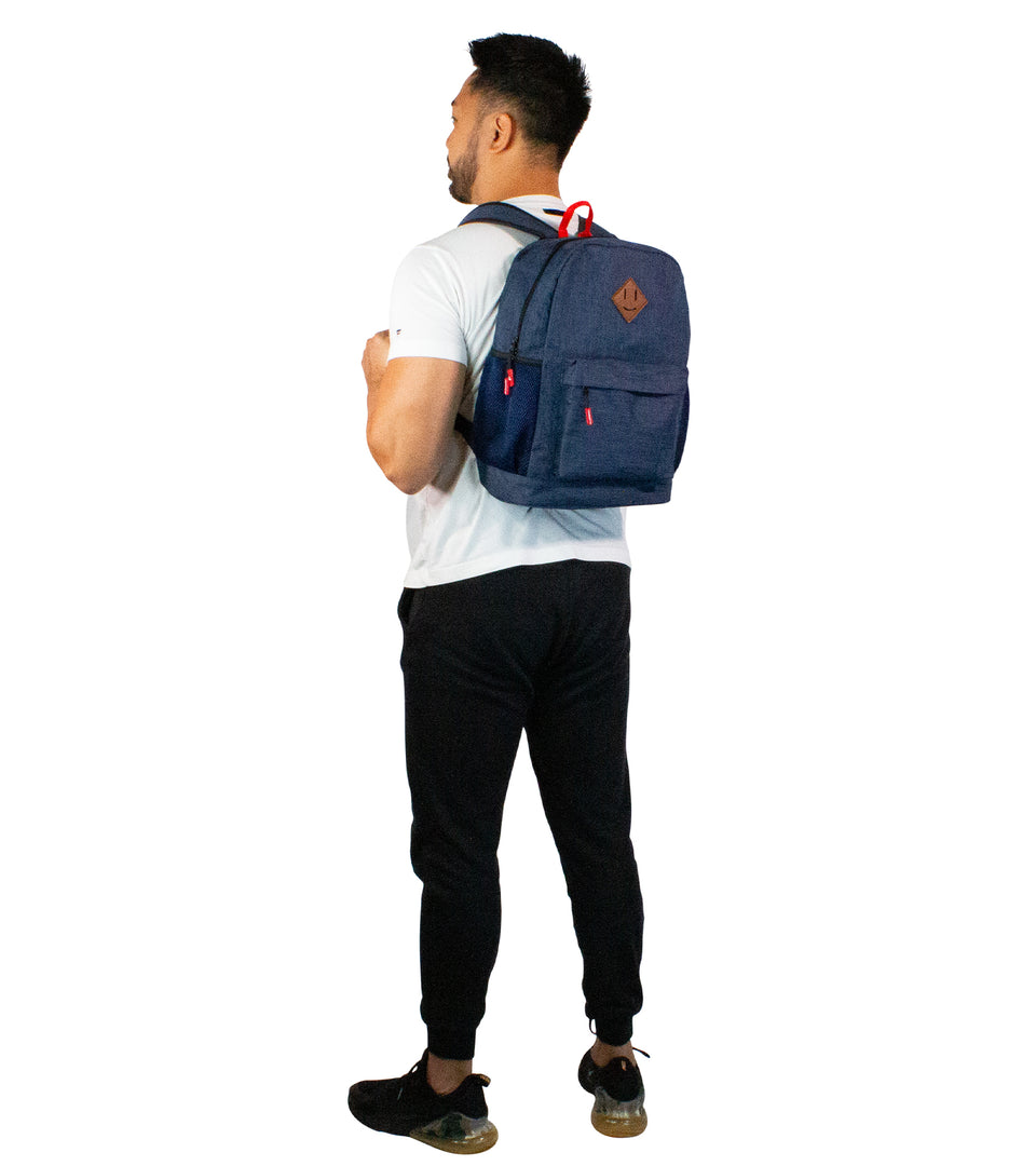 3/4 profile rear view of standing male model wearing navy blue poly-fabric backpack strapped over both shoulders