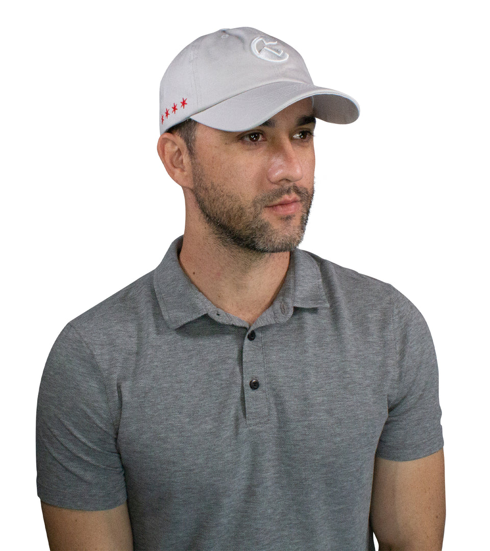 3/4 front view of male model wearing light gray cotton-nylon cap with white Conquer Life logo at front and red stars on side