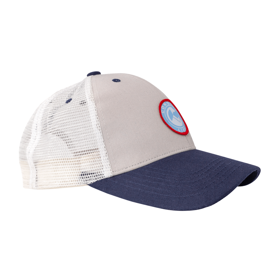 Side of light gray trucker hat with blue bill & circular, red, white, & light blue patch, back half of hat is white mesh 