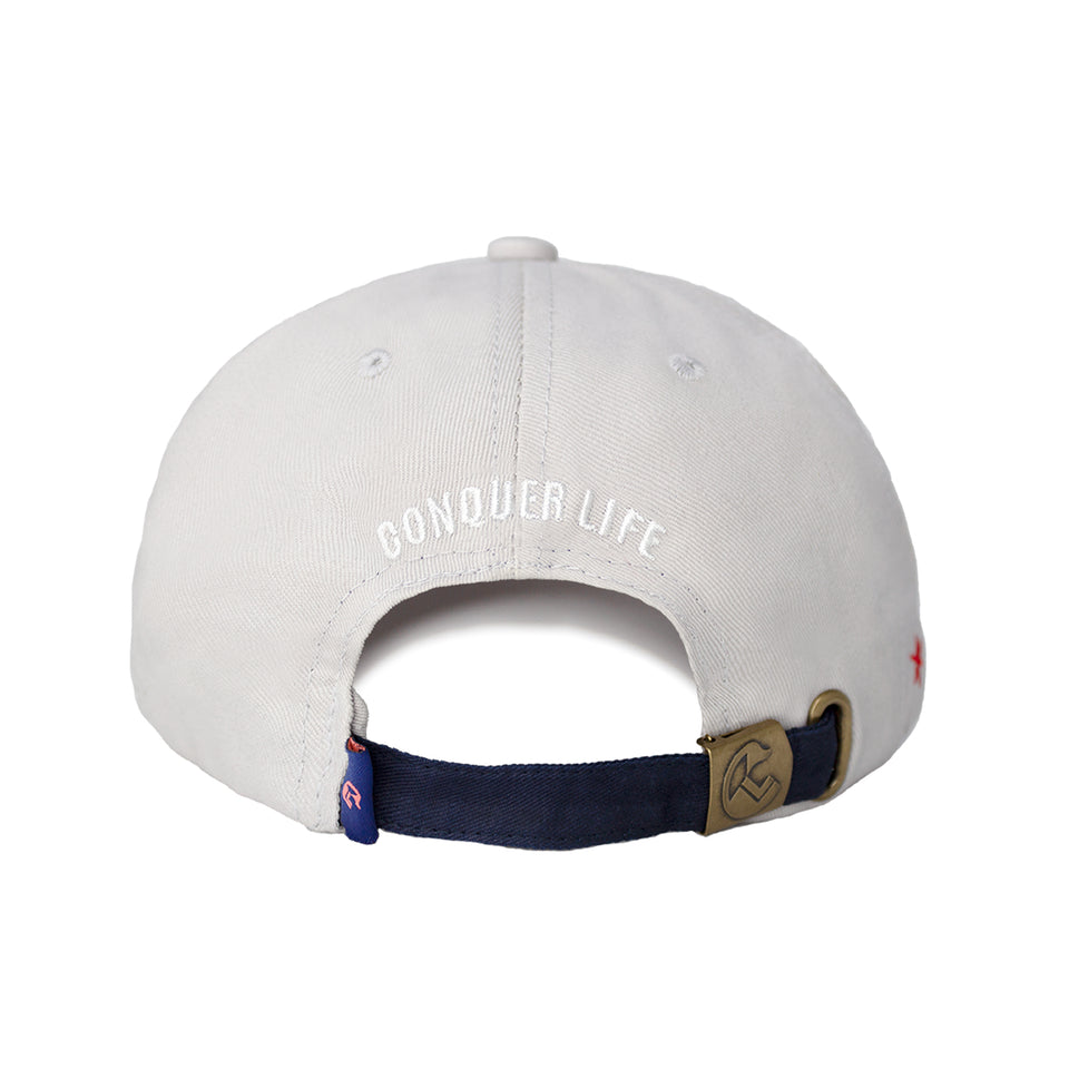 Rear view of cap, strip of navy fabric and bronze metal hinge to adjust fit, Conquer Life embroidered in white capitals
